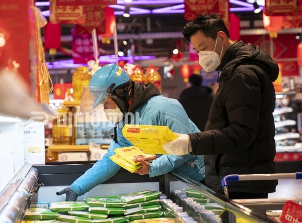 모든 것이 정지되어 있는 중국 후베이성 우한에서 고객을 대신하여 상품을 고르고 있는 택배인의 모습, 사진제공=신화사