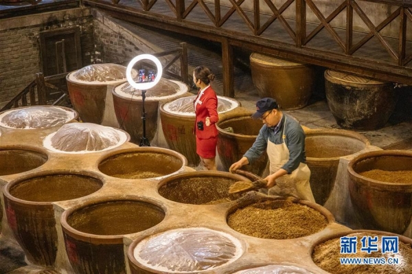 중국의 장장Zhenjiang에 있는 식초문화박물관 직원이 라이브 스트리밍을 통해 식초를 판매하고 있다