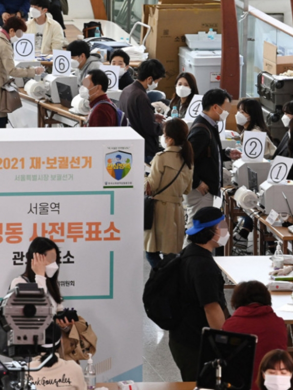 서울역에 마련된 서울시장 보궐선거 사전투표소에서 투표를 하고 있는 유권자들