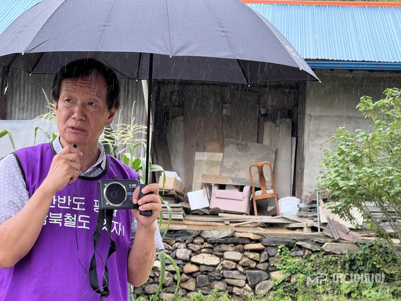 비가 내리는 가운데 우산을 쓴 이용길 회장은 미소띤 얼굴로 "민촌이 10대에 살았던 큰고모 집이 있는 분텃골은 분토가 나서 붙여진 이름"이라고 덧붙여 설명했다. / 사진 =강승혁 전문 기자