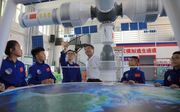 즈강소학교 학생들과 교사 위티엔샹(于天祥)이 우주항공에 대해 함께 관찰하며 학숩하고 있는 모습, 사진제공=黑龙江日报