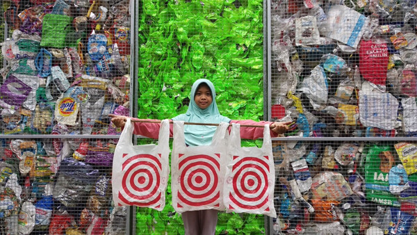 인도네시아 환경활동가 니나(12)가 미국 플라스틱 폐기물이 도착한 것에 항의해 미국 할인매장업체 타겟 가방을 펼쳐보이고 있다. 바젤행동네트워크(BAN) 제공